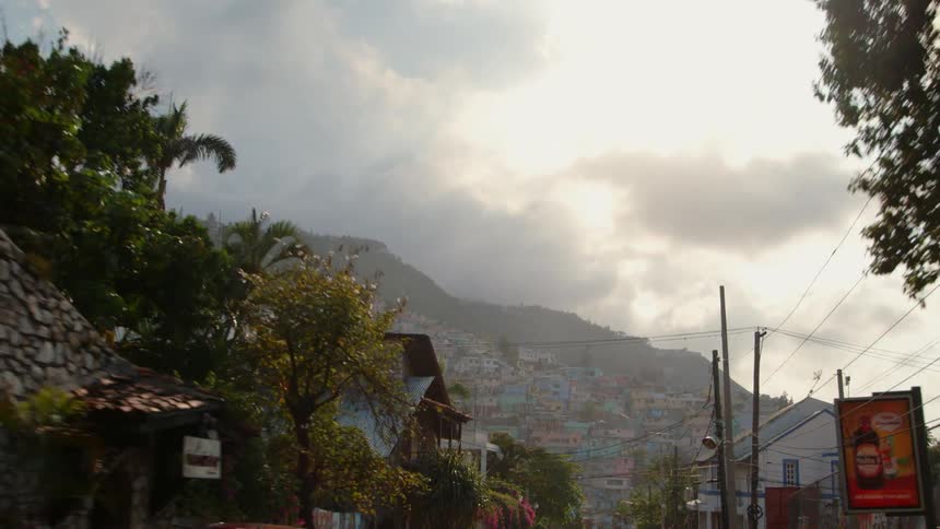 Clouds hang over the hills of a tropical community