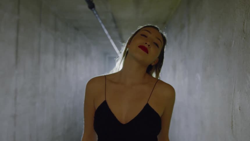 A woman is smiling and flirting while walking in a tunnel