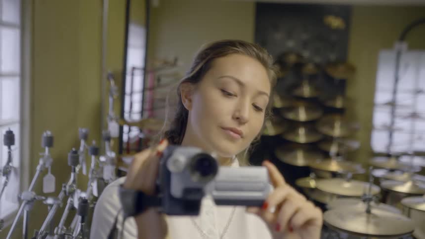 A woman is using a camcorder and laughing