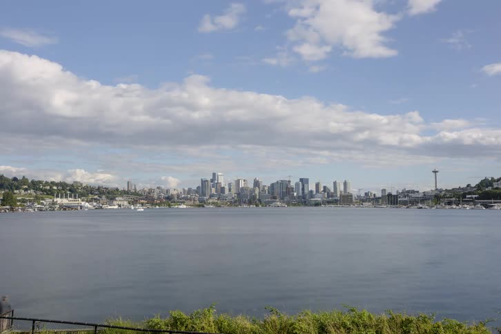 Clouds move over a city as boats navigate its bay throughout the day