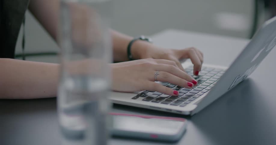 Woman types on a laptop