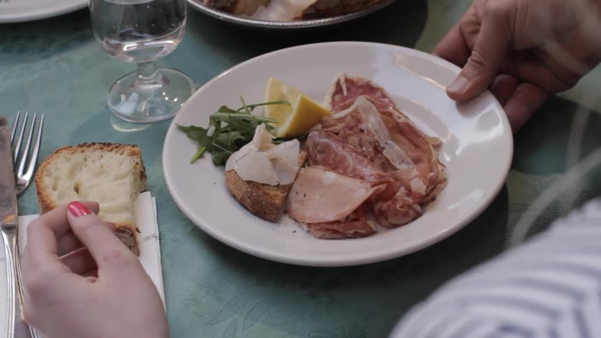A plate of food being served to a woman sitting at a table