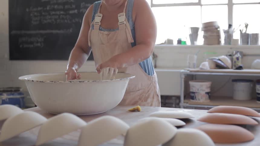 A woman is making bowls