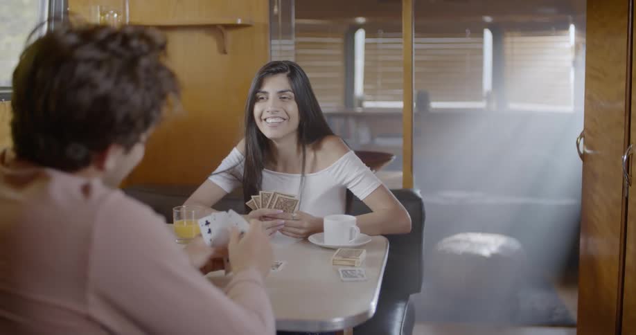 Couple plays cards at table in trailer home