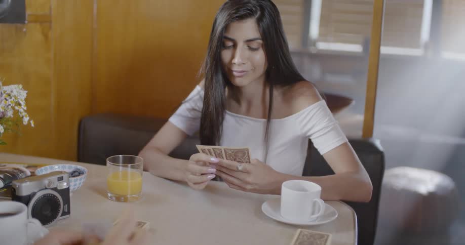 A woman smiles as she plays a game of cards