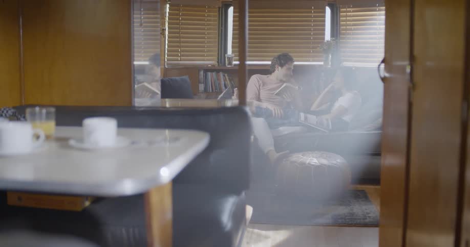 Man and woman sitting on couch reading book together