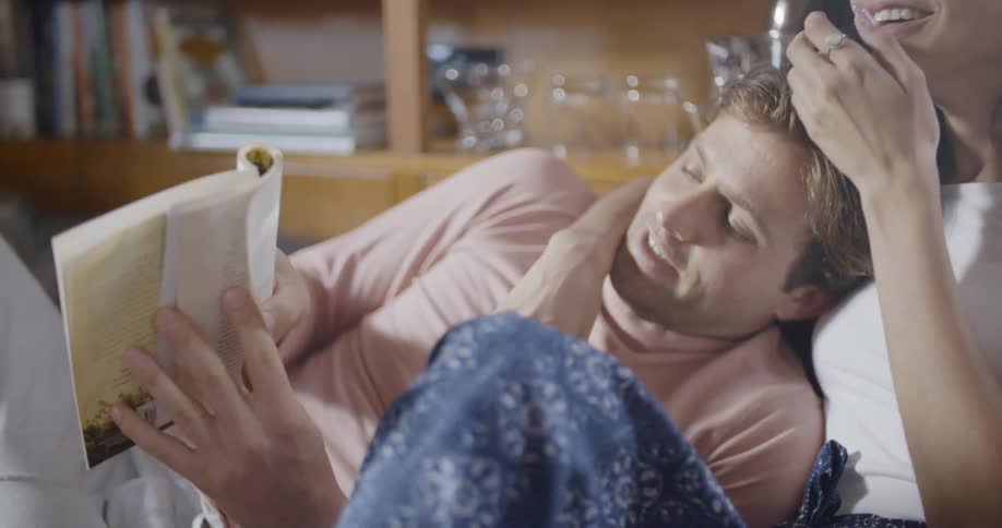 Man turns a page in a book as he sits next to a woman