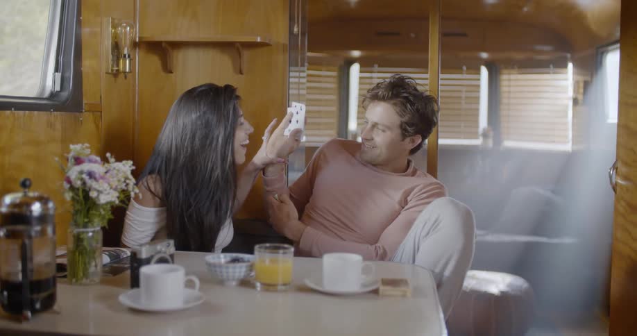 A man and woman play cards at a table