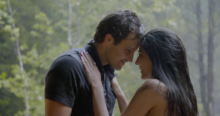 A woman hugs and talks with a man as it rains on them