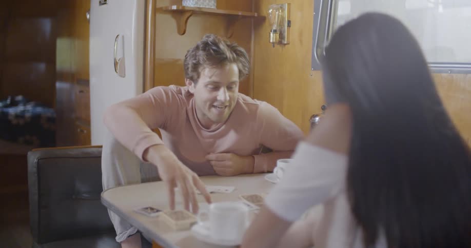A man and woman smile and play cards together