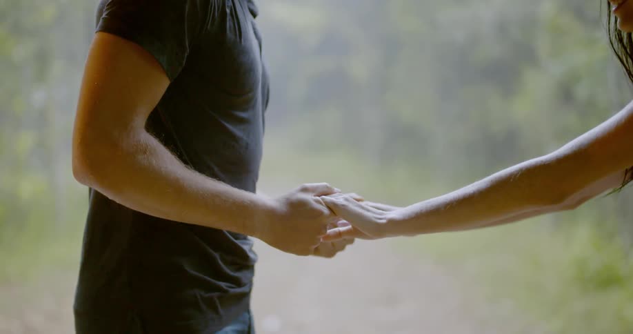 A man and woman are holding hands together outdoors