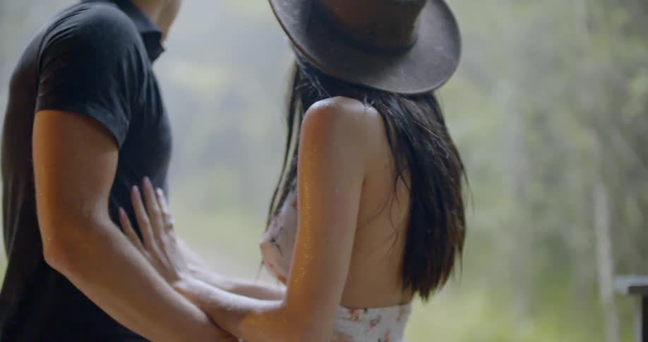 Woman runs her hands down a man's chest