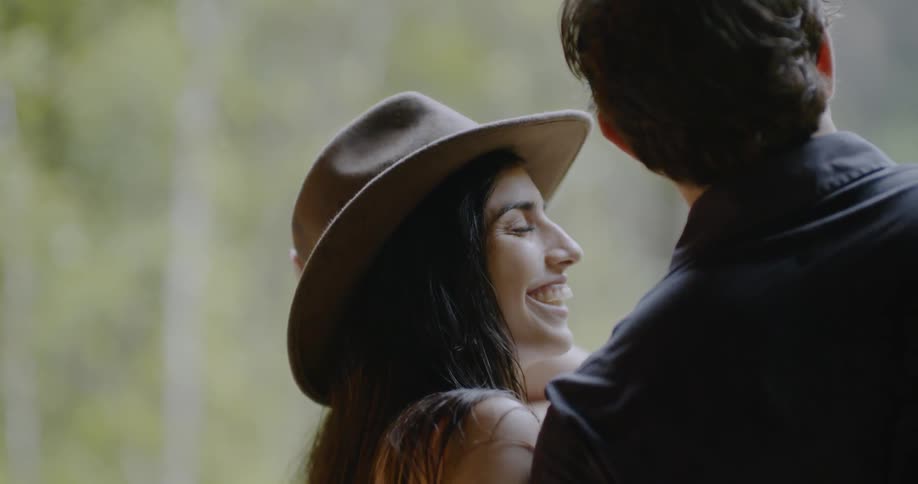 Woman wearing a hat talks with a man standing next to her