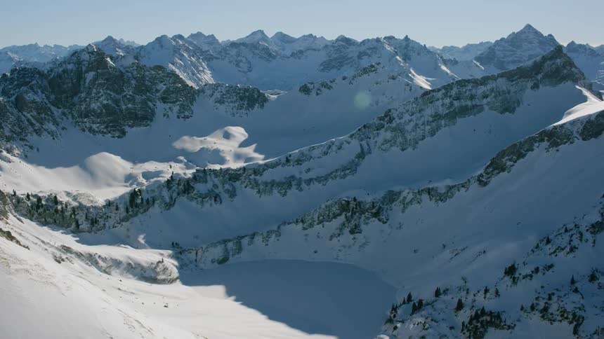 Snow covered mountain range on sunny day