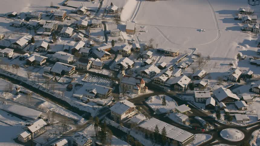 A village in a mountain valley is blanketed in snow