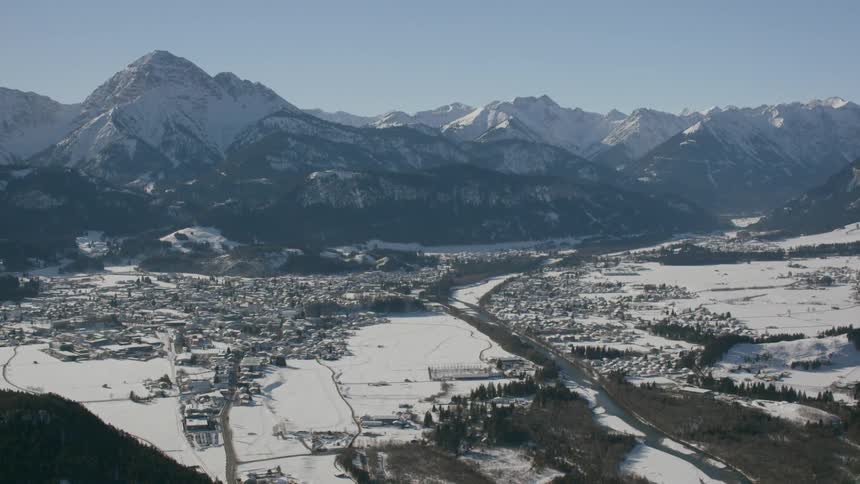 A snowy field at the base of a mountain