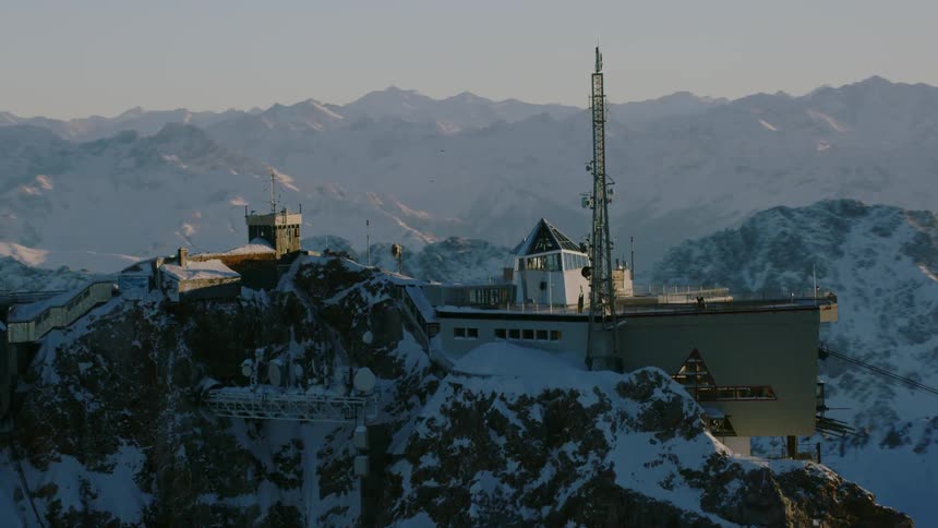 The mountain has some houses on the edge and an antenna