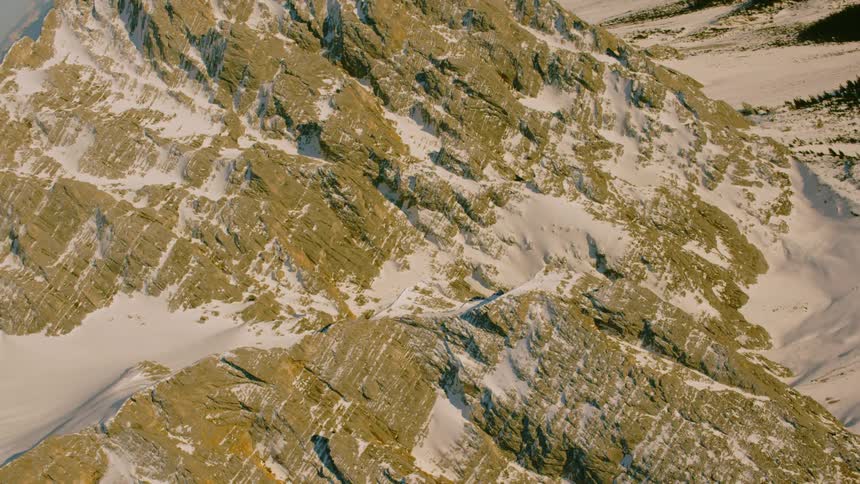 Snow covers a rocky mountain ridge