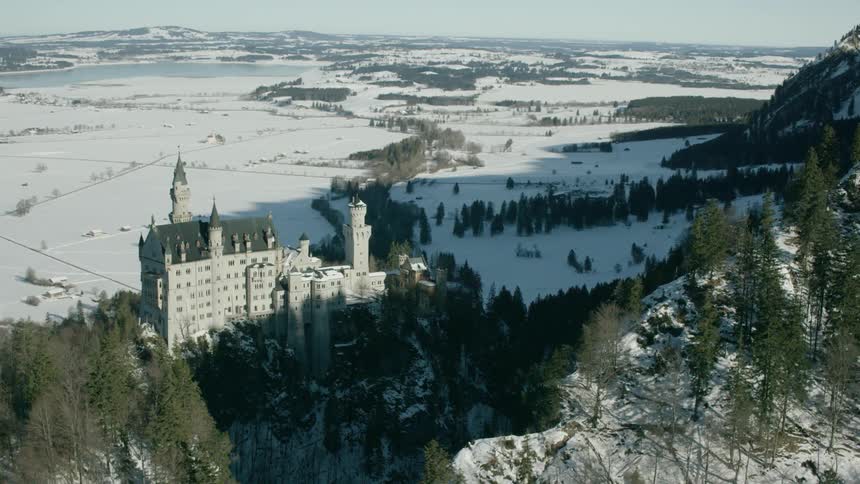 A castle sits in snowy mountains