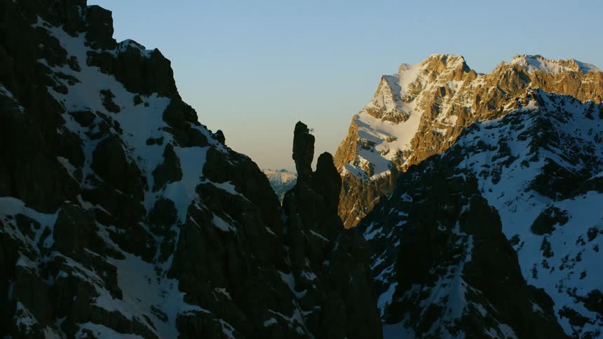 Snow covers a rocky mountain ridge