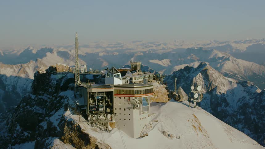 A building sits on a snowy mountain peak