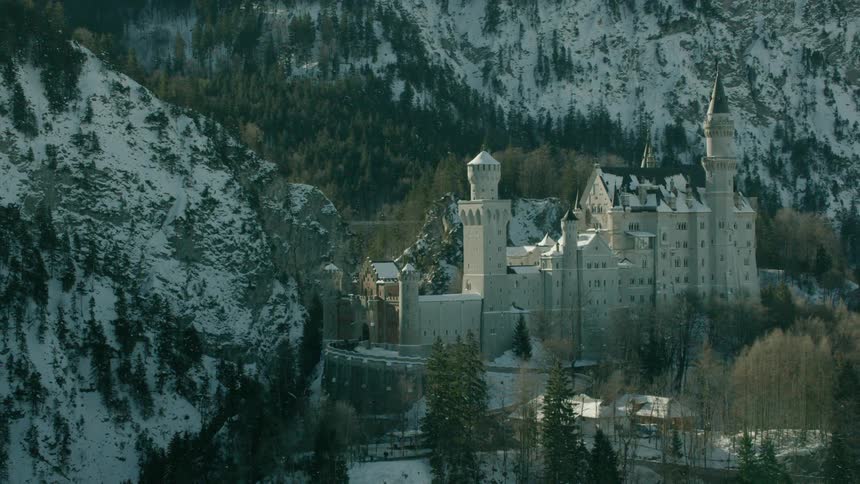 A castle sits in snowy mountains