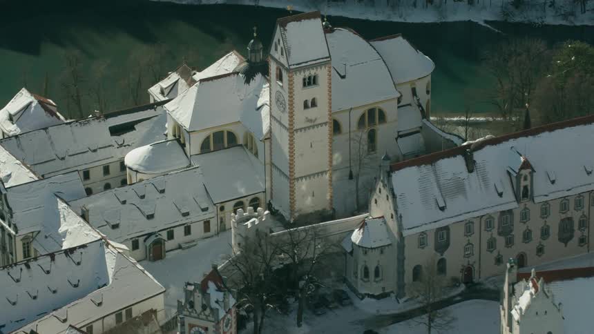 A river is flowing past old buildings in an old village in winter