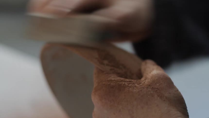 A woman is sanding a bowl