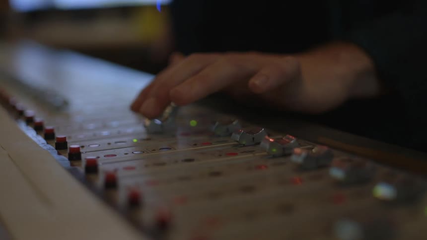 A person adjusting sliders on a control panel