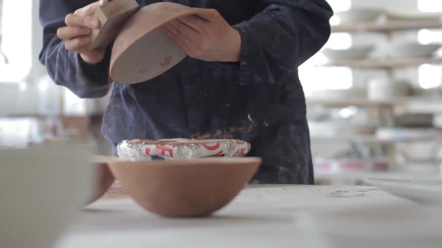 Person sanding a bowl and pouring out some contents