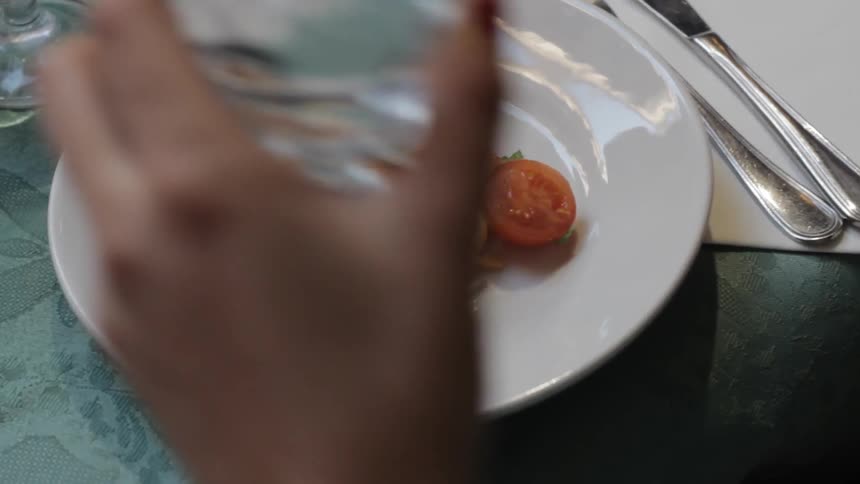 A person sits down to eat a plate of pasta