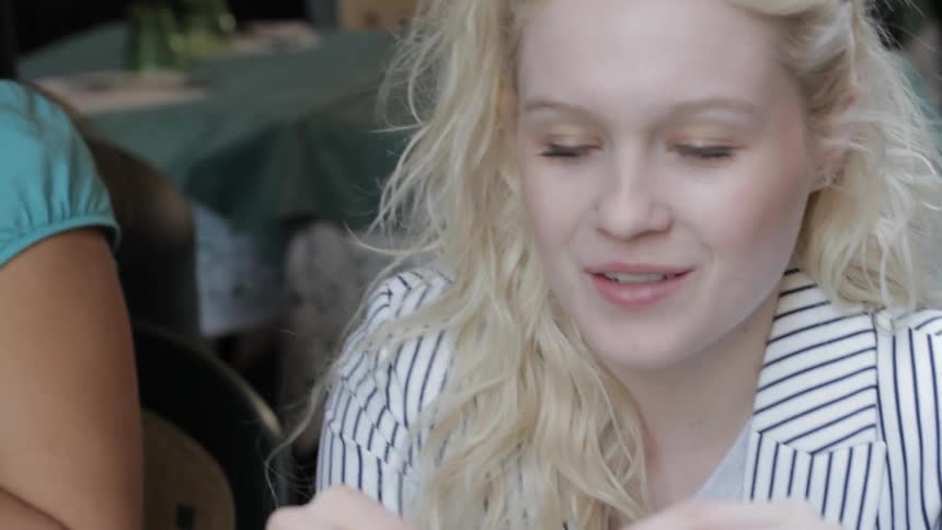 A woman is eating while telling a story