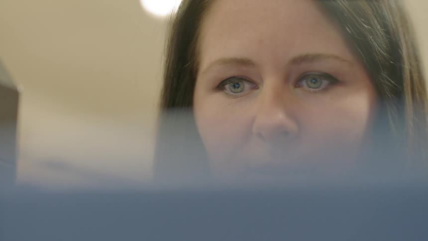 Woman stands in front of a computer screen