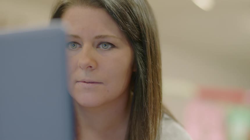 A woman looks at a computer monitor