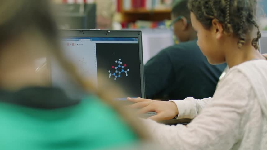 Children work on laptops in a classroom