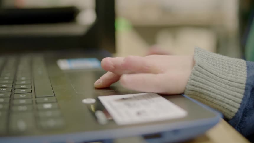 A child uses a laptop in a classroom