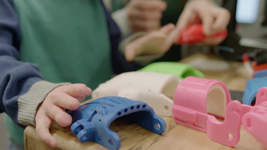 Boy with hand deformities looks at prosthetics