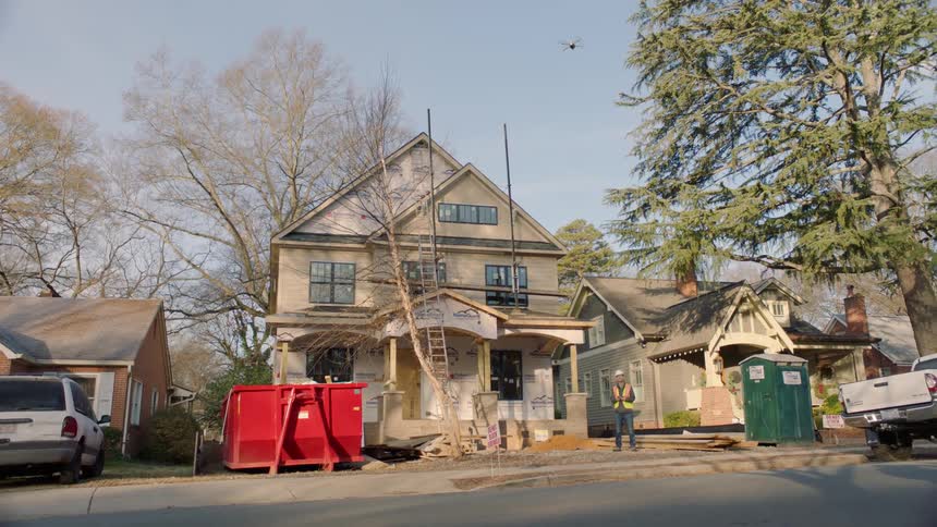 A drone flies above a house being renovated