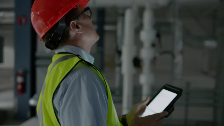 A man in a hardhat inspects a room