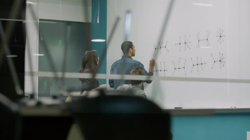 Employees work in front of a whiteboard