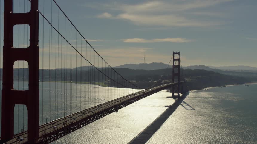 A ship floats beneath the golden gate bridge