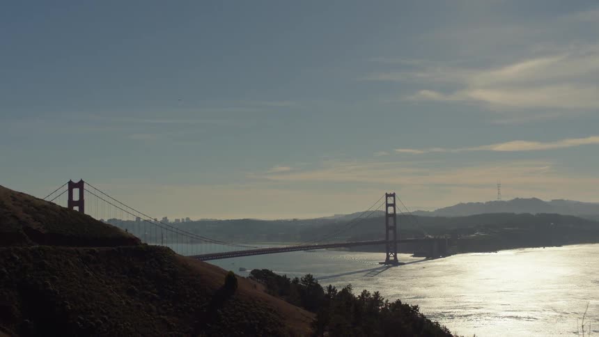 The golden gate bridge is filmed from a cliffside