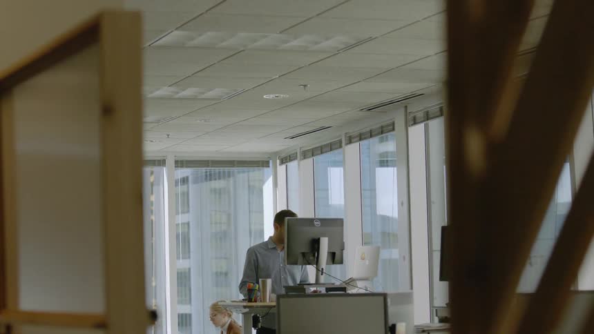 A man and woman are working in an office building during the day