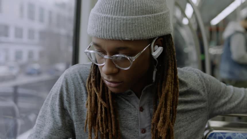 Man listens to headphones while riding public transit