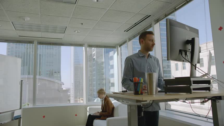 Man works at a standing desk in a city office