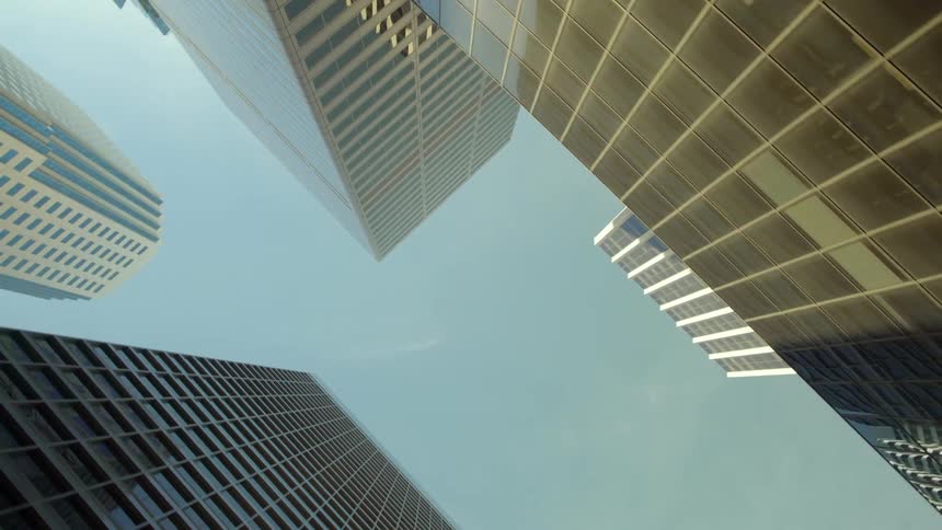 Glass windows in skyscrapers are reflecting the sky on a sunny day