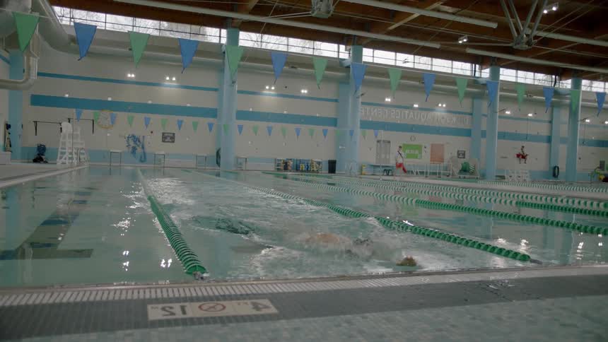 Person swimming in a large indoor pool