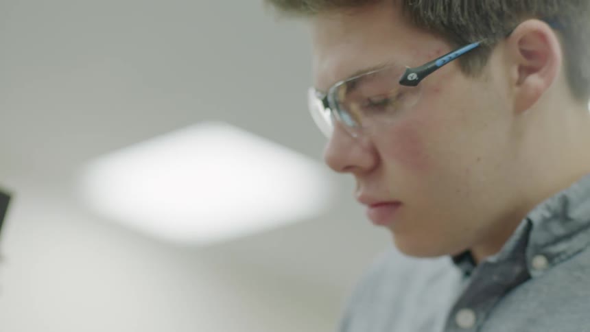 Boy wears safety goggles while working indoors