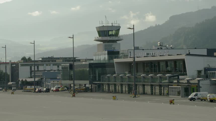 An airport building near mountains on hazy day