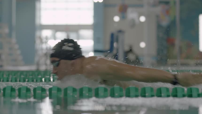 Man splashes and swims in a pool